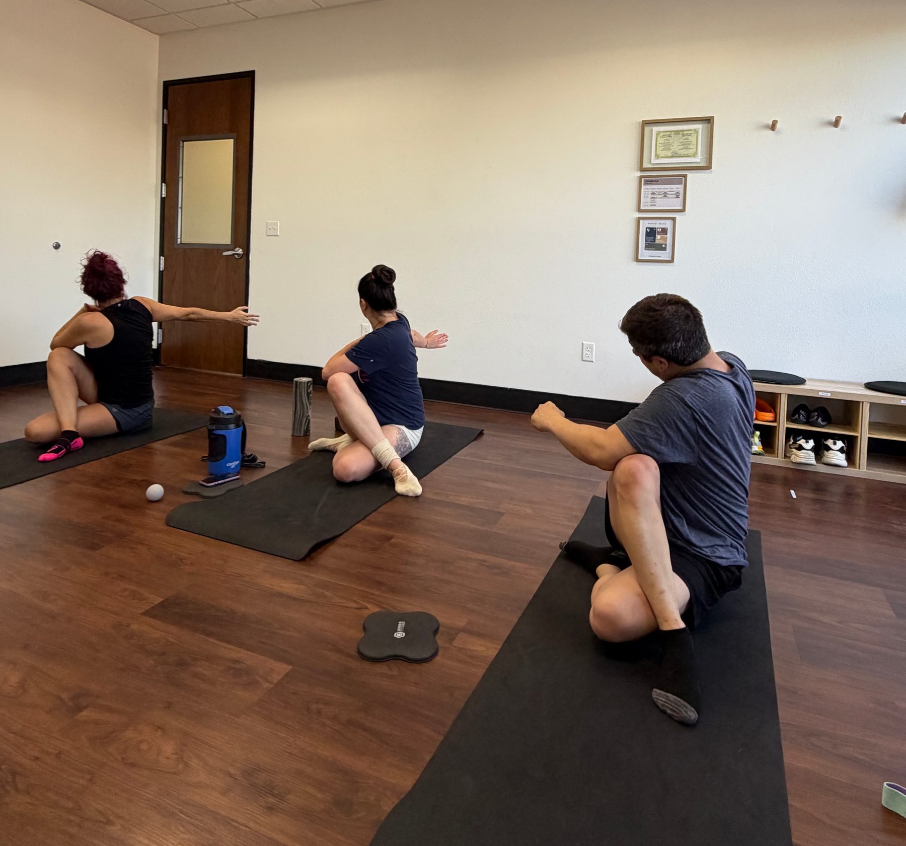 A small group of clients stretching on mats during a class at Coach Ilona Studio