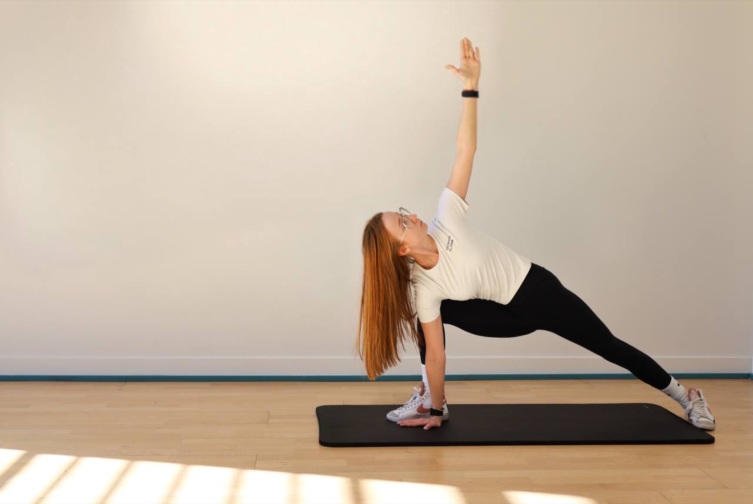 Coach Ilona in a deep side-angle stretch on a mat in her Las Vegas studio